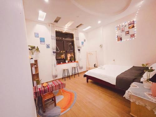 - une chambre avec un lit, une table et une fenêtre dans l'établissement House Thị Đà Lạt, à Đà Lạt