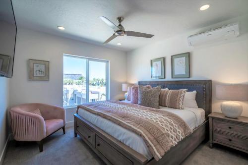 a bedroom with a bed and a chair and a window at 19| Vue at Green Valley with Community Pool in St. George