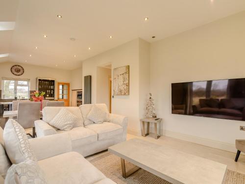 a living room with white furniture and a flat screen tv at Sunnyside Shreyas in Wilpshire