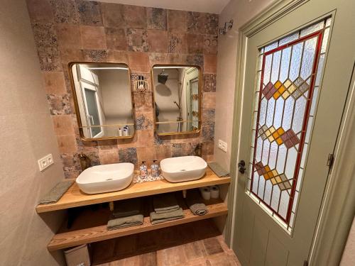 a bathroom with two sinks and two mirrors at Oniria Agradable casa con patio junto Mirador de San Nicolás in Granada