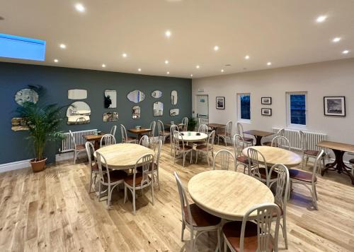 um restaurante com mesas e cadeiras num quarto em The Emsworth B&B Hotel em Emsworth