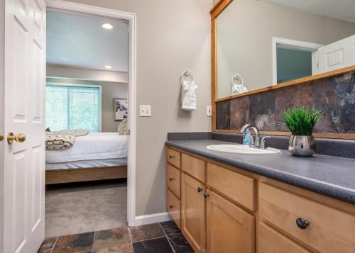 ein Bad mit einem Waschbecken und einem Spiegel sowie ein Schlafzimmer in der Unterkunft Union Gateway in Prime Salt Lake Location with Hot Tub in Midvale