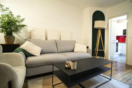 un salon avec un canapé et une table basse dans l'établissement Pretty 36 m near Buttes-Chaumont, à Paris