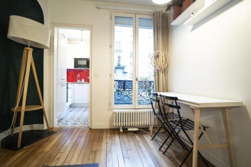 une cuisine avec une table et des chaises dans une pièce dans l'établissement Pretty 36 m near Buttes-Chaumont, à Paris