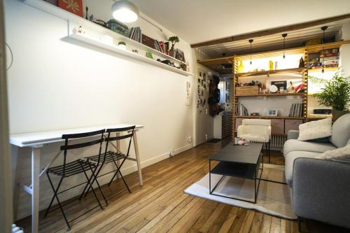 un salon avec une table et un canapé dans l'établissement Pretty 36 m near Buttes-Chaumont, à Paris