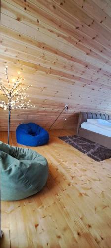 a room with a wooden ceiling with a bed and a tree at Wooden House Kopiti in Tbilisi City