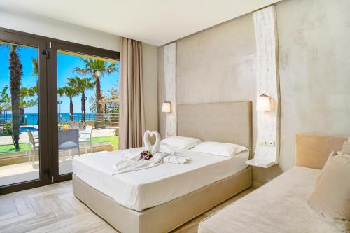 a bedroom with a bed and a view of the ocean at Blue view Hotel in Limenaria