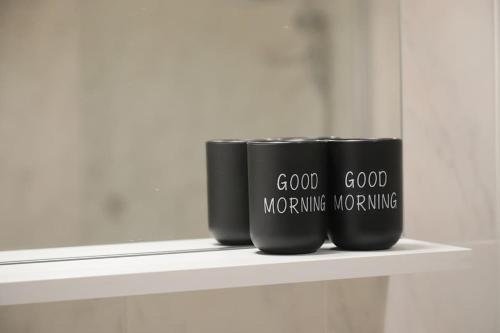two black coffee cups sitting on a shelf at Seaside Serenity - A lovely apartment with views in Mellieħa