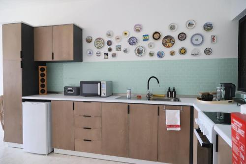 a kitchen with a sink and plates on the wall at Seaside Serenity - A lovely apartment with views in Mellieħa