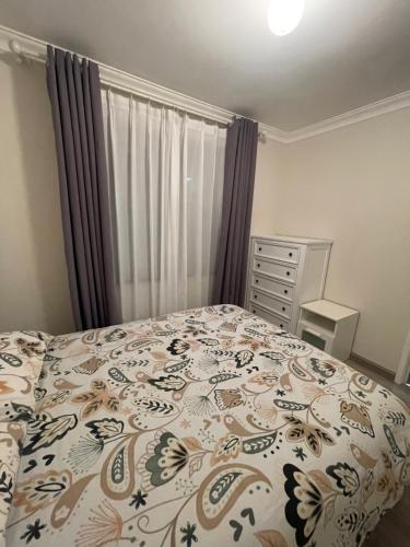 a bedroom with a bed with a floral bedspread at Easy Way Scarborough in Perth
