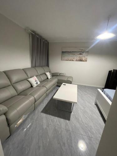 a living room with a couch and a table at Easy Way Scarborough in Perth