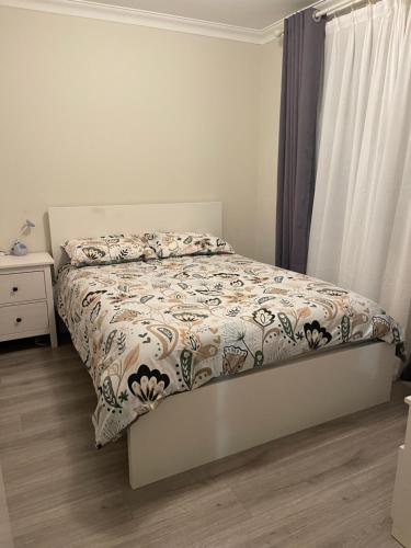 a bedroom with a bed with a comforter on it at Easy Way Scarborough in Perth