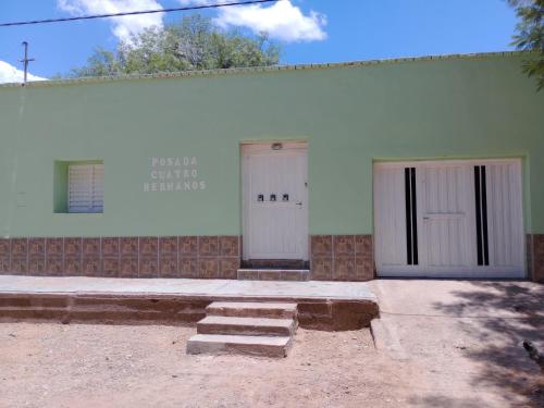 a building with two doors and steps in front of it at POSADA CUATRO HERMANOS in Tinogasta
