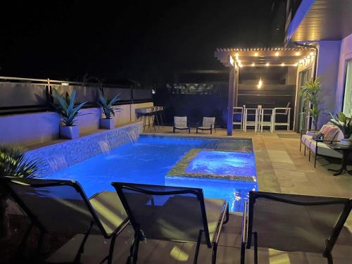 a swimming pool at night with chairs around it at 30 | Poolhouse at Ocotillo Springs with Private Pool and Views in Santa Clara