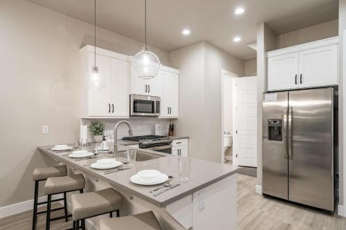 a kitchen with white cabinets and a stainless steel refrigerator at 30 | Poolhouse at Ocotillo Springs with Private Pool and Views in Santa Clara