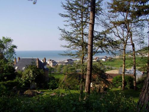 - une vue sur l'océan depuis la cour arborée dans l'établissement La Villa Marguerite, à Pourville-sur-Mer