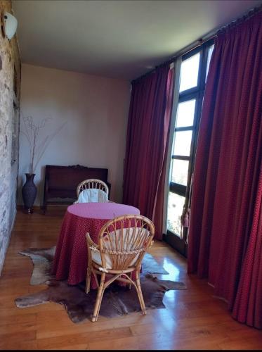 een kamer met een tafel, 2 stoelen en een raam bij Pazo de San Lorenzo in Puebla de Trives