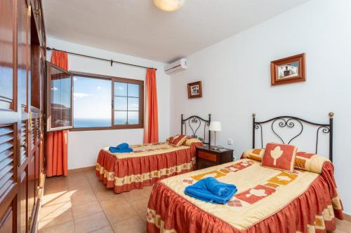 two beds in a room with a window at Villa El Callao in La Asomada