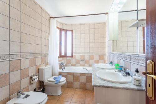 a bathroom with two sinks and a toilet and a tub at Villa El Callao in La Asomada