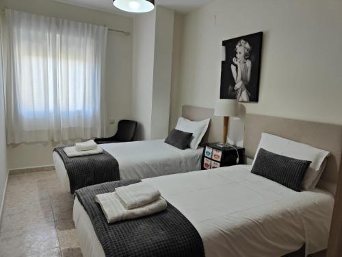 une chambre d'hôtel avec deux lits et une chaise dans l'établissement Apartamento Martina, à Jarandilla de la Vera