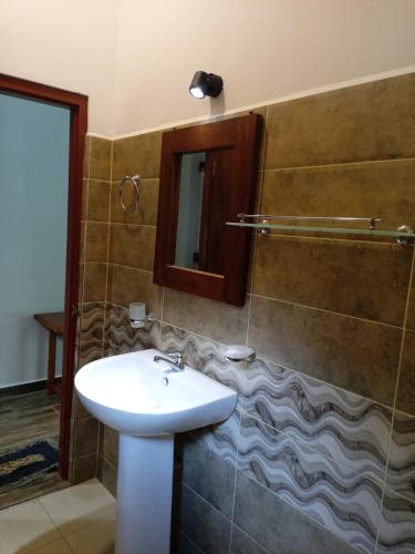 un baño con lavabo y espejo en Old Bridge Riverside Hotel, en Kitulgala