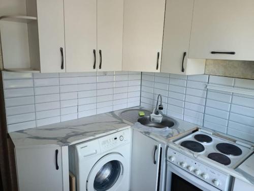 a kitchen with a washing machine and a sink at Сozy apartment,16-1 Satpayev in Ustʼ-Kamenogorsk