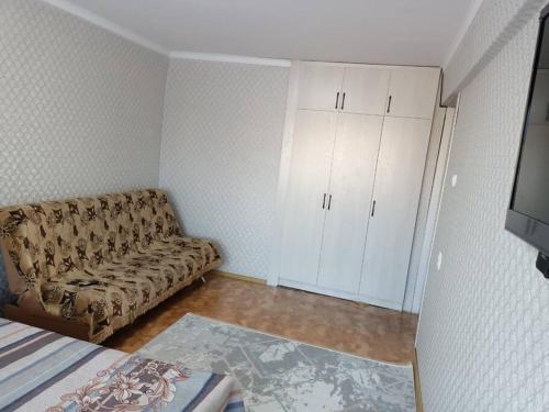a living room with a couch and white cabinets at Сozy apartment,16-1 Satpayev in Ustʼ-Kamenogorsk
