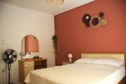 a bedroom with a white bed and a red wall at Seaside Serenity - A lovely apartment with views in Mellieħa