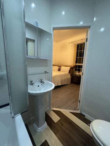 a bathroom with a sink and a bedroom with a bed at Valencia in Blackpool