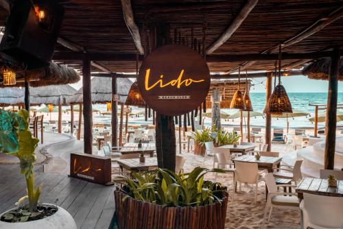 a restaurant on the beach with tables and chairs at Hotel Colibri Beach in Playa del Carmen
