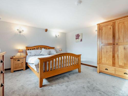 a bedroom with a wooden bed and a wooden cabinet at 1 Bed in Polperro OVERH in Lansallos