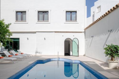 a swimming pool in the courtyard of a house at Hotel Infanta Leonor in Écija