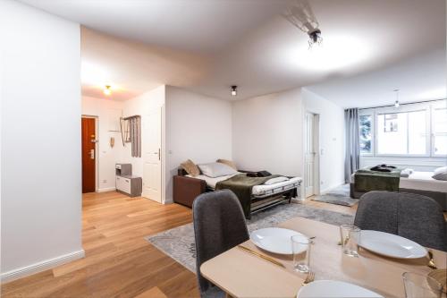 ein Wohnzimmer mit einem Tisch, Stühlen und einem Sofa in der Unterkunft Family Apartment in Wien