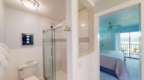 ポーリーズ・アイランドにあるExperience Coastal Elegance 3BR True Blue Villa!のバスルーム(シャワー付)、ベッドルーム(ベッド1台付)が備わります。