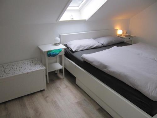 a small bedroom with a bed and a window at Sperrentalblick in Sankt Andreasberg