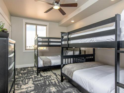 two bunk beds in a room with a ceiling fan at Sage Creek E1 in Moab with Scenic Community Pool in Moab