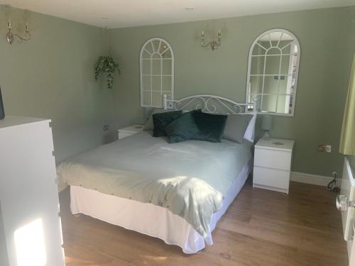 a bedroom with a white bed with two mirrors at Scott’s lodge in Kent