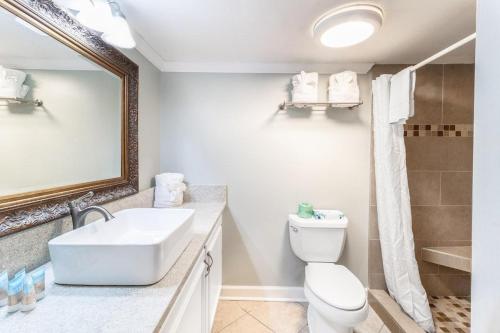 uma casa de banho com um lavatório, um WC e um espelho. em Beach Bliss Haven, OF Tower Room 6th Floor em Pawleys Island