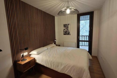 エスカリリャにあるMimosa 4 con terraza - tucasaenlospirineosの白いベッドと窓のある寝室