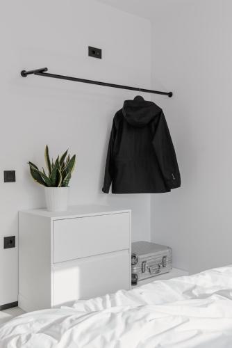 a black jacket hanging on a wall next to a bed at No Stars - Premium Hotel Apartments in Ioannina