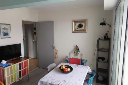 Cette chambre comprend une table avec un bol de fruits. dans l'établissement Apartment with balcony close to the beach, à Cabourg