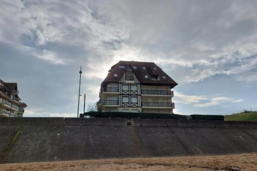 a building with a roof on top of a wall at Apartment with balcony close to the beach in Cabourg