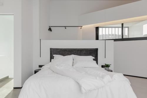 un letto bianco con lenzuola e cuscini bianchi di No Stars - Luxury Hotel Apartments a Ioannina