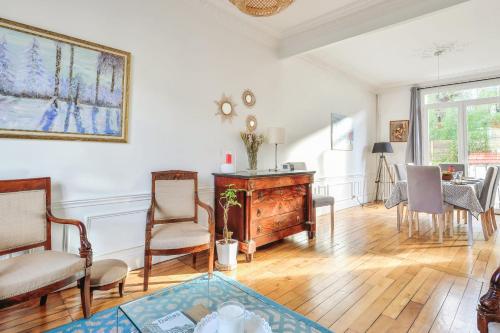 een woonkamer met een tafel en stoelen bij Charming large house in Courbevoie - Welkeys in Courbevoie