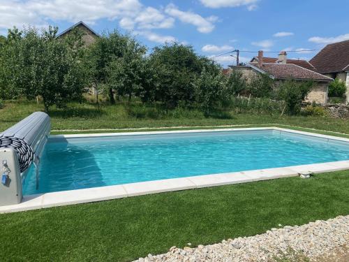 a swimming pool with a slide in the grass at Chez Odette 