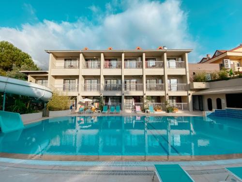 a hotel with a swimming pool in front of a building at Ölüdeniz Günlük, haftalık ve aylık apart. in Fethiye