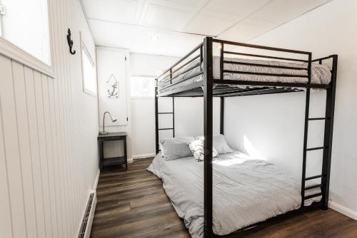 1 Schlafzimmer mit 2 Etagenbetten in einem Zimmer in der Unterkunft Chalet bord du lac! Plage privée! Vues imprenables! in Roberval