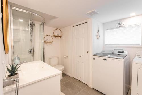 ein weißes Bad mit einem Waschbecken und einem WC in der Unterkunft Chalet bord du lac! Plage privée! Vues imprenables! in Roberval