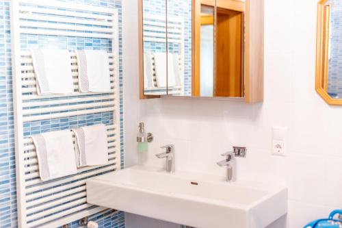 a bathroom with a sink and a mirror and towels at Bio-Bauernhof Auernig in Obervellach
