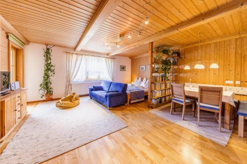 a living room with a blue couch and a table at Bio-Bauernhof Auernig in Obervellach